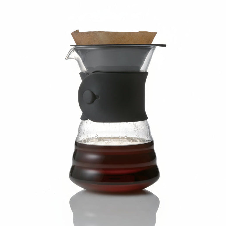 Coffee brewing device with glass carafe and wooden filter on a white background